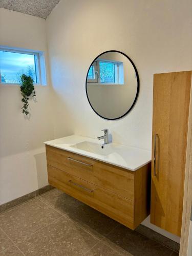 a bathroom with a sink and a mirror at 2-Family Activity Cottage in Rønde
