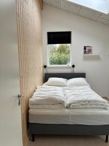 a large bed in a room with a window at 2-Family Activity Cottage in Rønde