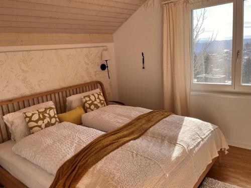 a bedroom with a bed with a large window at B&B Alpenblick in Erlinsbach