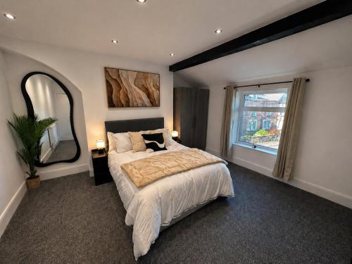a bedroom with a large bed and a large window at The Carlton Collection in Birkenhead