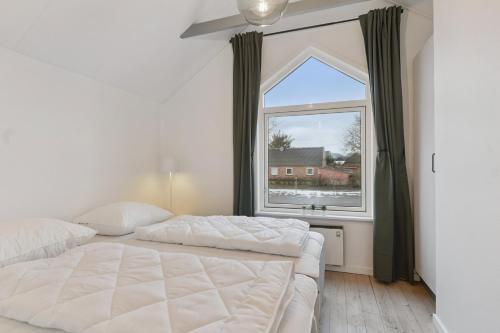 a bedroom with two beds and a large window at Holiday Apartment With Sea View in Hadsund