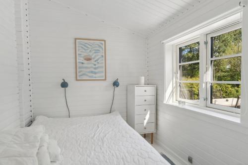 a white bedroom with a bed and a window at Cozy Holiday Home in Nyrup
