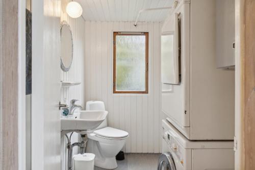 a white bathroom with a toilet and a sink at Holiday Home And Annex Surrounded By Nature in Ebberup