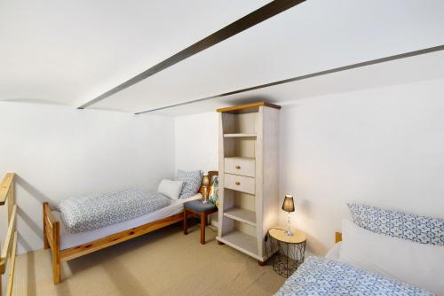 a bedroom with two beds and a book shelf at Tiny Appartment Xanten am See in Xanten