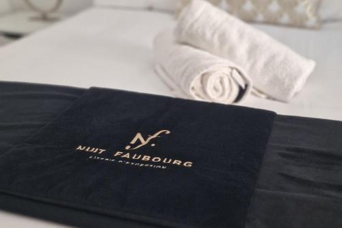 a black towel sitting on top of a bed at Marguerite - Charme et confort in Orange
