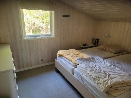 a bedroom with a bed in a room with a window at Natural Plot Fireplace And True West Coast in Thisted