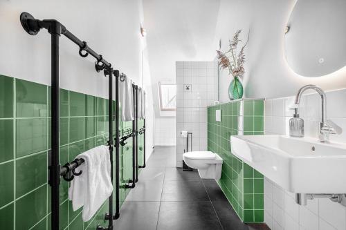 a green and white bathroom with a sink and a toilet at Lennepserf - T Marsje in Veessen