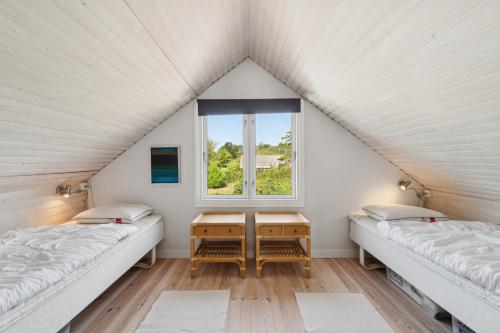 two beds in a room with a window at Panoramic View And Denmarks Best Beach in Neksø
