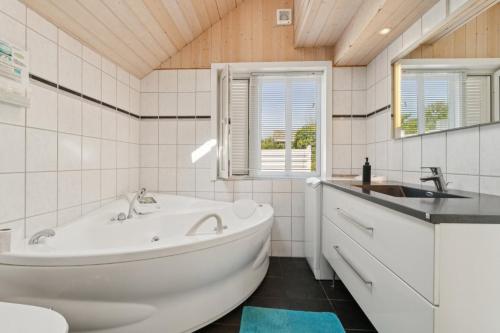 a white bathroom with a tub and a sink at Panoramic View And Denmarks Best Beach in Neksø
