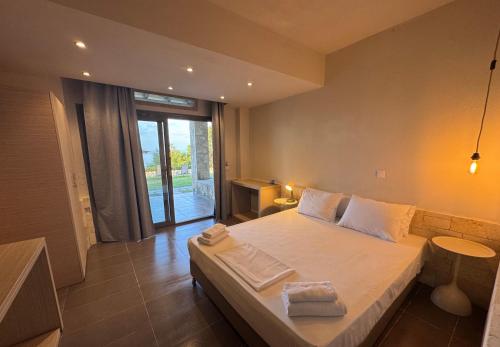 a bedroom with a large bed and a large window at nafsea in Afitos