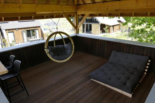 a porch with a chair and a swing at Lennepserf - De Bok in Veessen