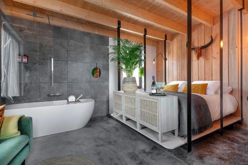 a bedroom with a bed and a bath tub next to a bed at Lennepserf - De Bok in Veessen