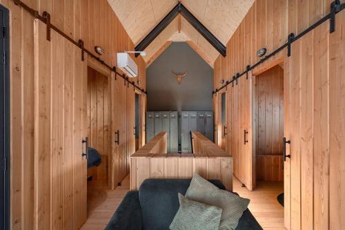 a room with wooden walls and a blue couch at Lennepserf - De Pinkels in Veessen