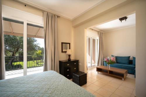 a bedroom with a bed and a couch and a window at Villa Renata -Pool, Large Garden & Free Parking, 2 Minutes Walk from The Beach in Barbati