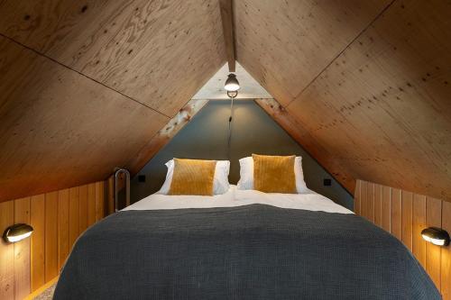 a bedroom with a large bed in a attic at Lennepserf - De Achterhoek in Veessen