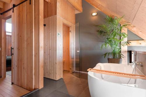 a bathroom with a tub and a potted plant at Lennepserf - De Achterhoek in Veessen