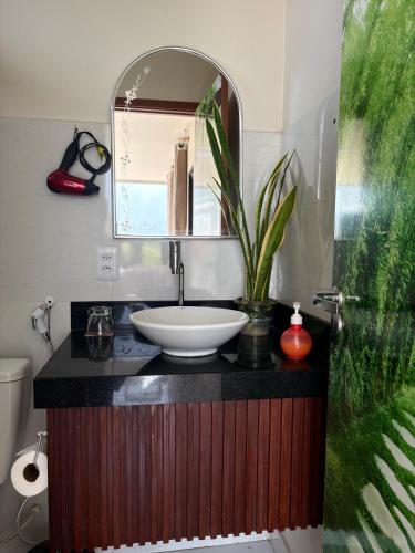 a bathroom with a sink and a mirror at Pousada Mão de Deus in Vila Tepequém