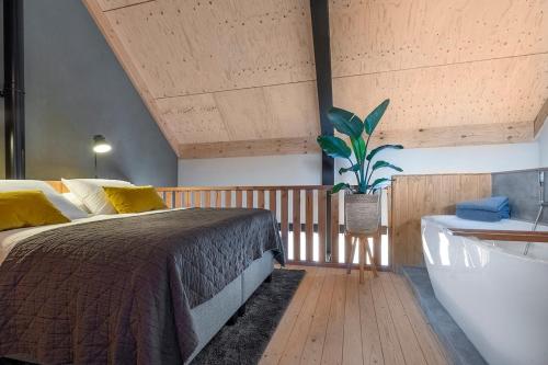 a bedroom with a bed and a tub and a plant at Lennepserf - De Horstjes in Veessen