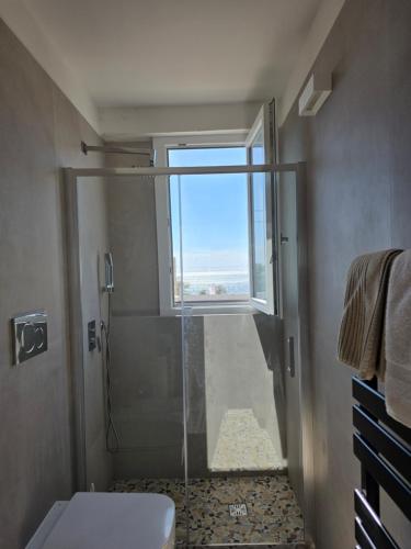 a bathroom with a shower with a window at A 34 passi dal mare in Torre Ovo