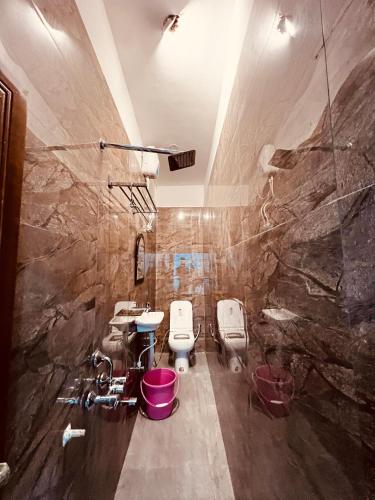 a bathroom with two toilets and a stone wall at ramraz residency in Ayodhya