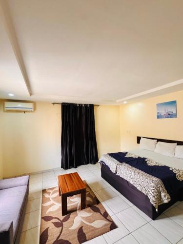 a bedroom with a bed and a table in it at Sea-Point Homes in Maiyegun