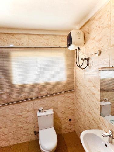 a bathroom with a toilet and a sink at Sea-Point Homes in Maiyegun