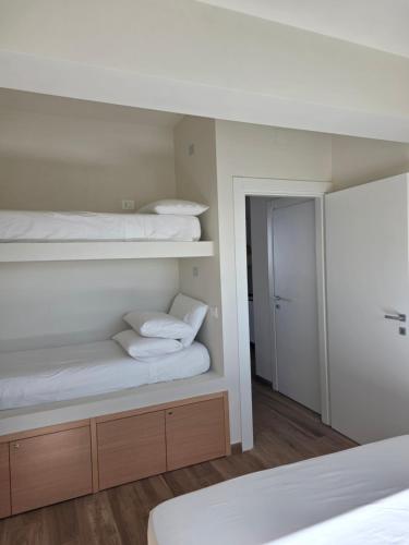 a bedroom with two bunk beds and a mirror at A 34 passi dal mare in Torre Ovo