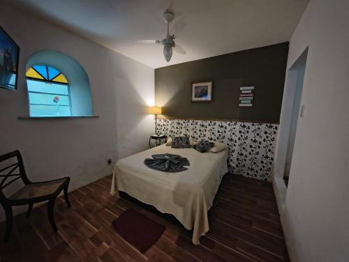 a bedroom with a bed and a chair and a window at Casa Caminho do Meio in Rio de Janeiro