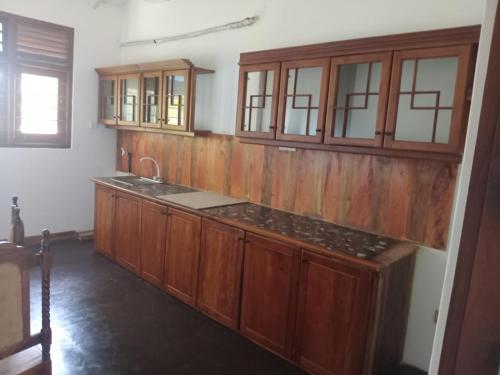 a kitchen with wooden cabinets and a sink at Kurana Resident in Katunayaka