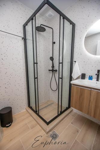a glass shower in a bathroom with a sink at Euphoria Central Living in Stavros