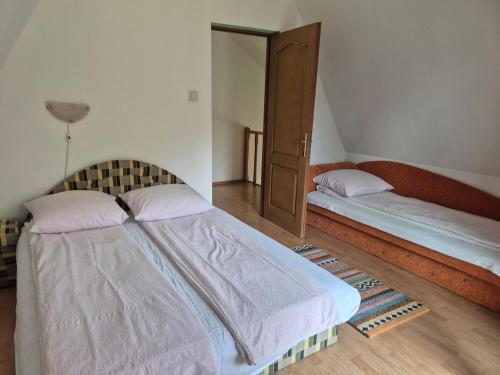 a bedroom with two beds and a cabinet at Csendliget kulcsosház in Sub Cetate