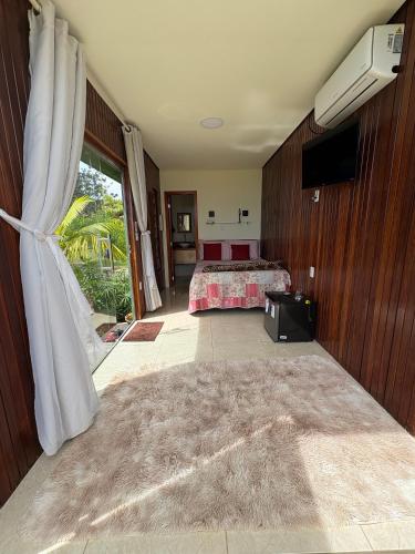 a bedroom with a bed and a television in it at Pousada Mão de Deus in Vila Tepequém