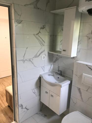 a white bathroom with a sink and a toilet at Apartments Suljovic in Ulcinj