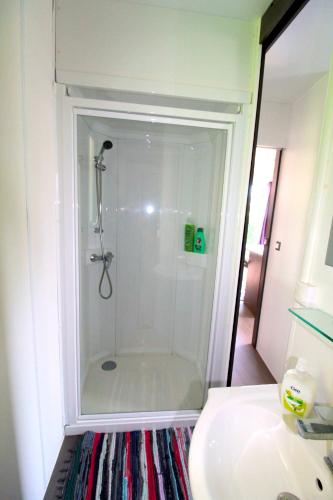 a shower in a bathroom next to a sink at Lodges camp in Setúbal
