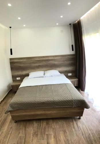 a bedroom with a large bed with a wooden headboard at Apartments Suljovic in Ulcinj