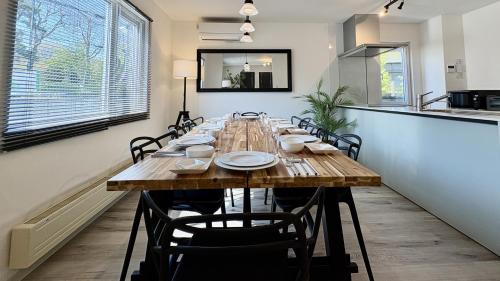 a long wooden table in a room with chairs at Ts House Hakodate Park Front in Hakodate