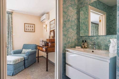 a bathroom with a sink and a chair and a mirror at 139 e 140 Casa dos Carvalhos in Castelo Branco