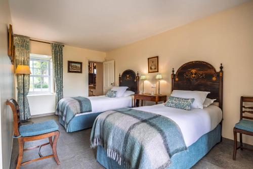 a hotel room with two beds and a chair at 139 e 140 Casa dos Carvalhos in Castelo Branco
