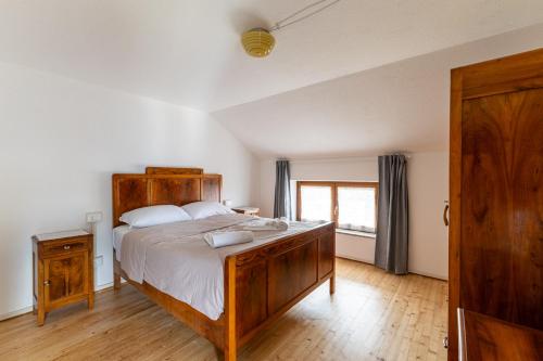 a bedroom with a large wooden bed and a window at Casa di Angelina in Avaglio