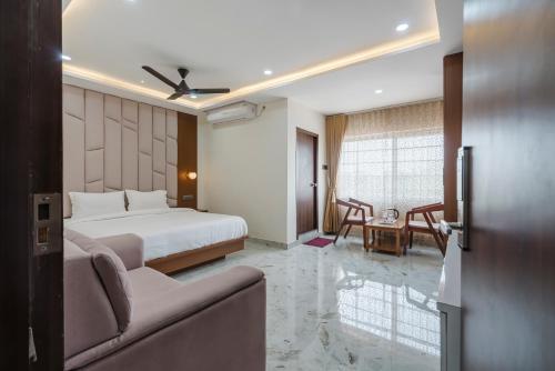 a hotel room with a bed and a living room at Hotel Rasballa Grand in Bhadrāchalam Road