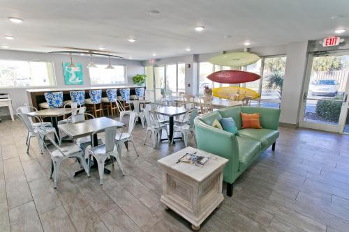 a restaurant with tables and chairs and a couch at Surf & Sand Hotel in Pensacola Beach