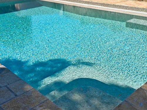 a shadow of a man standing in a swimming pool at Paxos Dream House in Vlachopoulátika