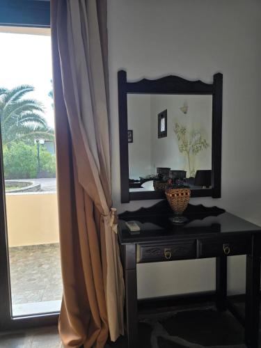 a dressing table with a mirror and a window at Amalthia hotel in Límni