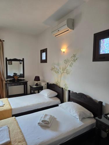 a bedroom with two beds and a mirror at Amalthia hotel in Límni