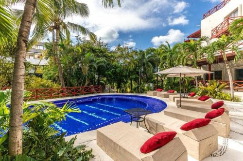 a resort swimming pool with red pillows and a table at Condo Solana Oceanview and Jungle Bliss! in Sayulita