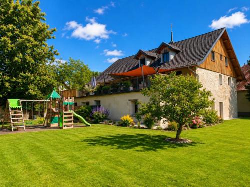 a house with a yard with a playground at Gîte des oursons - Climatisé in Guyans-Durnes
