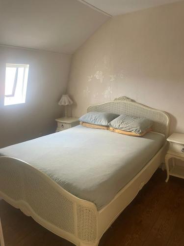 a white bed in a bedroom with a window at Oude Dorp Zicht in Urk