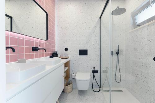 a bathroom with two sinks and a shower with pink tiles at Casa Alegra in Carvalhal