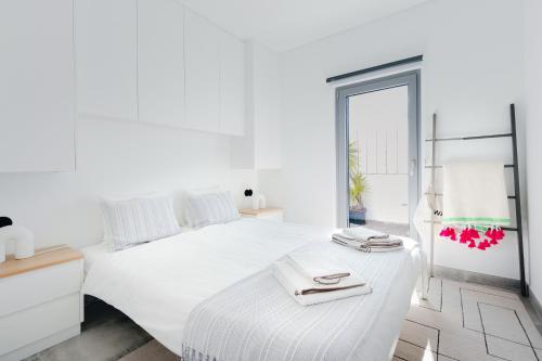 a white bedroom with a white bed and a window at Casa Alegra in Carvalhal