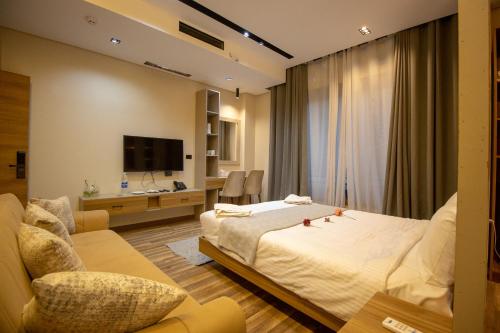 a hotel room with a bed and a tv at Farida Palace Hotel in Al Aqālitah